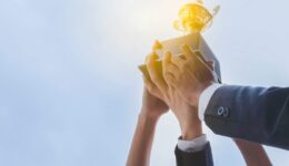 The best team helped each other reach their goals target to success. The hand of a business man and business women pick up the trophy and celebrate together. Teamwork of successful concept
