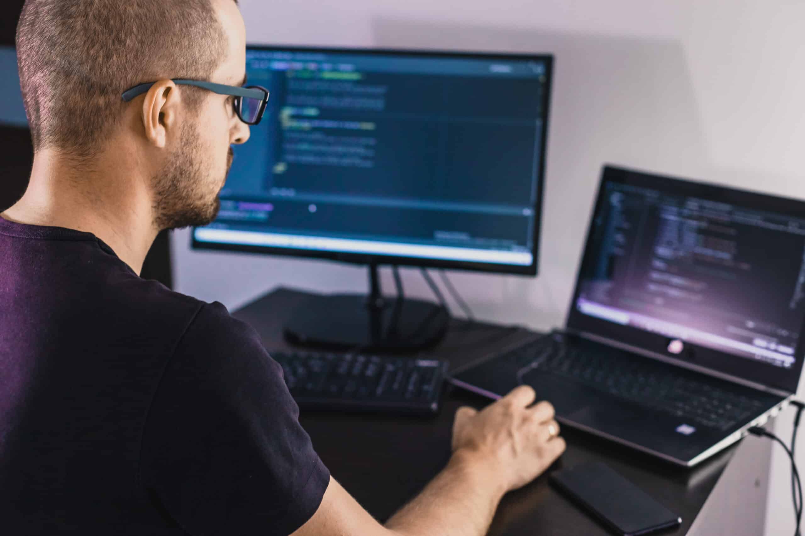 IT professional managing SQL scripts on dual monitors during an automated database migration, showcasing advanced database migration services.